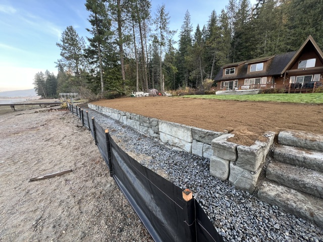 Lakefront retainer wall built with steps into the water, graded and ready for hydro-seed