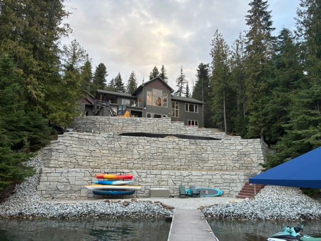 Finished multi-tier stone retaining wall on a North Idaho lakefront