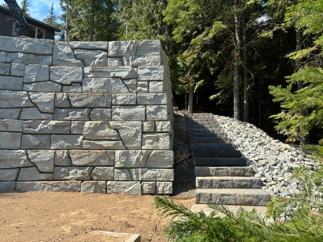 Grey stone retaining wall with stone slab steps